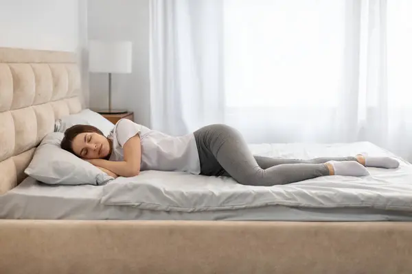 全身上下都是安详的女人 侧卧良好 休息良好 享受新鲜棉质床上用品 柔软的枕头和舒适的床垫 有免费的复印空间 — 图库照片