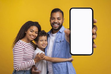 Beyaz ekranlı, boş akıllı telefon sergileyen, Afrikalı Amerikan annesini, babasını ve küçük oğlunu seven, yeni mobil uygulamayı veya internet sitesini kucaklayan ve eğlendiren üç kişilik neşeli siyah bir aile.