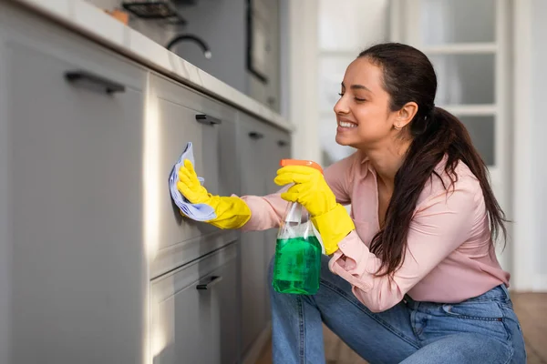 Smiling Woman Crouches Clean Her Kitchen Cabinets Spray Bottle Cloth — Stock Photo, Image