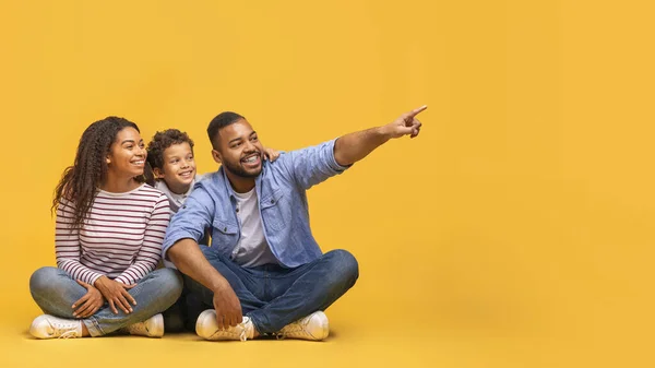 ナイス オファー ハッピーブラックの両親と小さな息子は コピースペース 広告デザインのための自由な場所を示す3つの陽気なアフリカ系アメリカ人の家族の脇に座っています パノラマ — ストック写真
