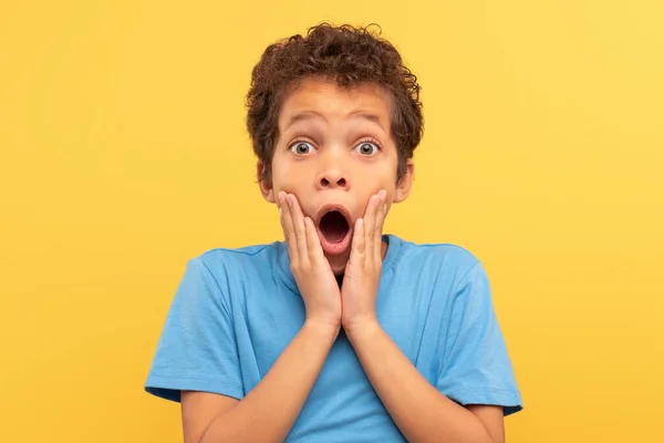 Shocked Boy Curly Hair Hands Cheeks Mouth Wide Open Astonishment — Stock Photo, Image