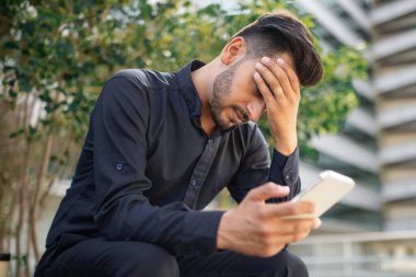 Sıkıntılı genç ortadoğulu işadamı, el ele tutuşarak, şehir dışında otururken telefonla kötü haberler alıyor, girişimcinin baş ağrısı üzerine kıyamet kopuyor.