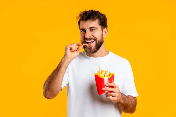 Smiling Young Guy Casual White Shirt Eating French Fries Yellow — Stock Photo, Image