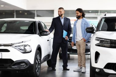 Gülümseyen Araba Satıcısı Müşteriye Tavsiye Veriyor, Satış Merkezinden yeni bir araba alan mutlu Hintli genç adam, Modern Otomobil Fuarında Satıcıyla Sohbet Ediyor
