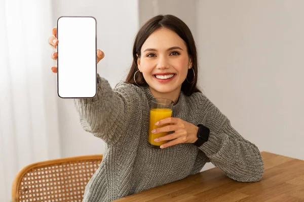 Fröhliche Junge Frau Mit Einem Glas Frischem Orangensaft Zeigt Handy — Stockfoto
