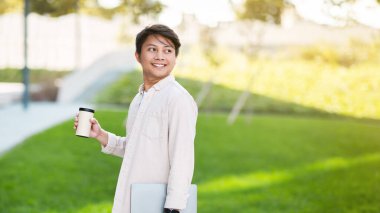 Milenyum Asyalı bir adam, serbest çalışan bir müteahhit, halka açık bir parkta kahve içiyor, dizüstü bilgisayarı tutuyor, iş toplantılarına gidiyor, fotokopi alanlarına bakıyor, panorama