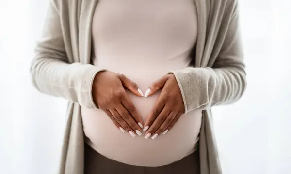 白い背景に隔離された大きな腫瘍 心臓型の看板に手を握っている黒人の妊婦のクロップ — ストック写真