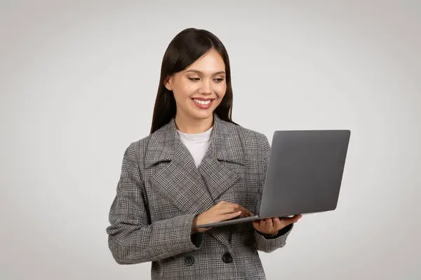 Zapojená Usmívající Mladá Podnikatelka Kostkovaném Saku Pracující Moderním Notebooku Reprezentující — Stock fotografie