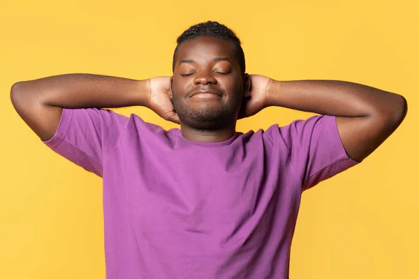 松懈的非洲裔美国人的画像 他们享受着片刻的和平 手挽手盖住黄色工作室的背景 闭着眼睛睡觉 身穿紫色T恤 — 图库照片
