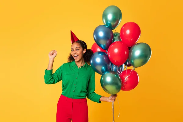 生日聚会和惊喜 快乐的黑人少女拿着一束明亮的气球 在黄色的工作室背景下欢快地庆祝她的节日 假日庆祝活动 — 图库照片