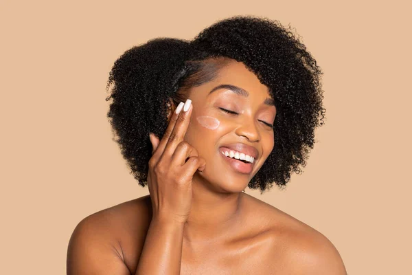 Fröhliche Afroamerikanerin Mit Natürlichen Haaren Die Freudig Gesichtsfeuchtigkeitscreme Auf Ihre — Stockfoto