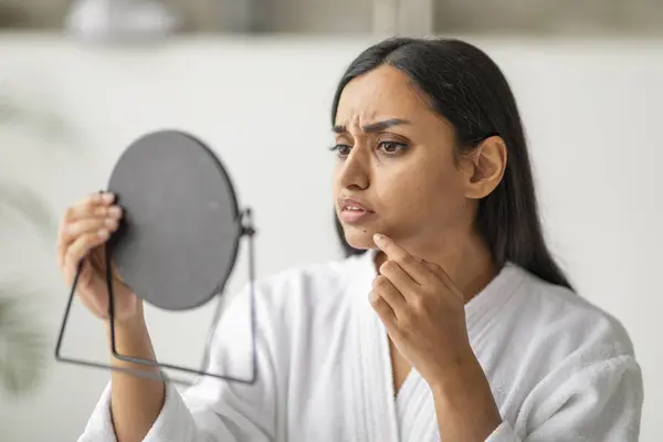 Infelice Orientale Giovane Donna Vestaglia Bianca Guardando Specchio Controllando Pelle — Foto Stock