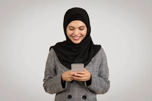 Mujer Sonriente Con Hijab Traje Negocios Absorto Envío Mensajes Teléfono —  Fotos de Stock