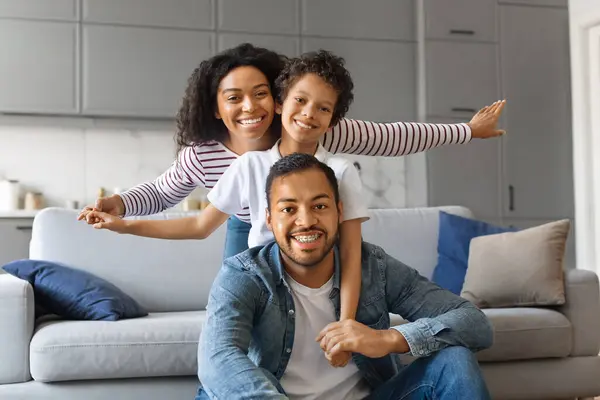 快乐的非洲裔美国人父母与儿子在家里结合 快乐的黑人家庭与男孩在客厅里玩乐 嬉笑玩耍 快乐的一起度过时光 — 图库照片