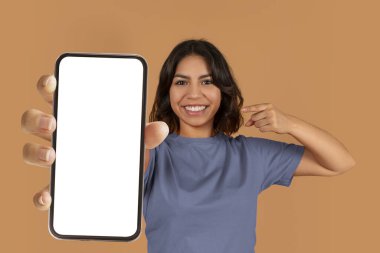 Mobil uygulama, online teklif. Neşeli, güzel, orta doğulu bir kadın elinde renkli arka planda izole edilmiş, beyaz beyaz ekran fotokopi alanı olan akıllı telefonu işaret ediyor.