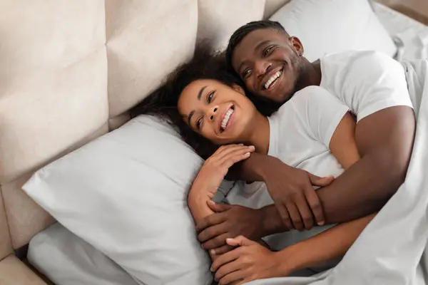 Glückliches Millennial Schwarzes Paar Flirtet Und Umarmt Morgen Auf Bequemen — Stockfoto