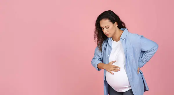 Молодая Беременная Женщина Страдающая Болей Родах Изолирована Розовом Фоне Студии — стоковое фото