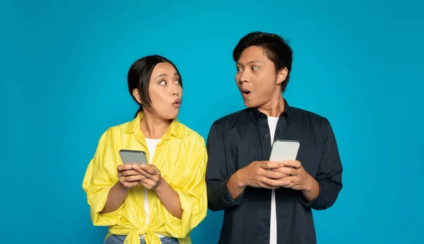 Şok Olmuş Çinli Kadın Erkek Ellerinde Şaşırmış Ifadelerle Akıllı Telefonlar — Stok fotoğraf