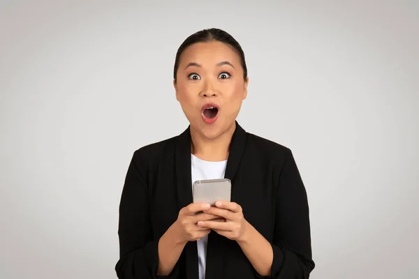 Şaşırmış Asyalı Kadını Geniş Gözlü Ağzı Açık Akıllı Bir Telefon — Stok fotoğraf