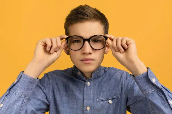 Menino Adolescente Focado Camisa Jeans Ajustando Seus Grandes Óculos Pretos — Fotografia de Stock