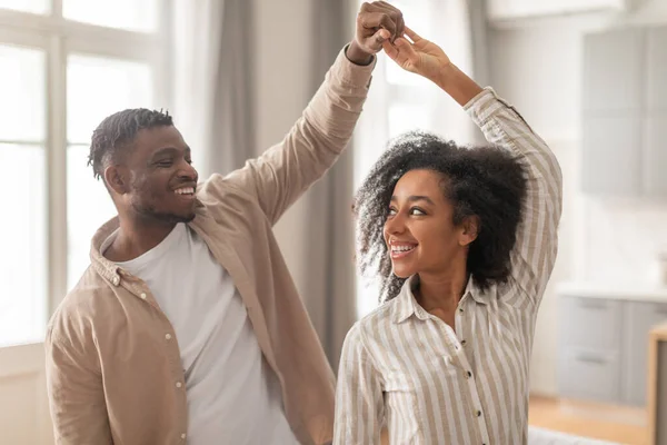 Party For Two. Happy Loving African American Couple Sharing Their Dance Enjoying Romantic Weekend Moments In Modern Living Room Interior. Shot Of Young Spouses Dancing At Home