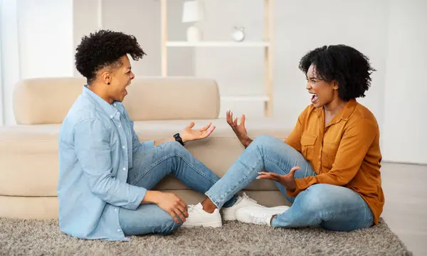 Sad Young Couple Sits Floor Having Bad Conversation Expressive Gestures — Stock Photo, Image