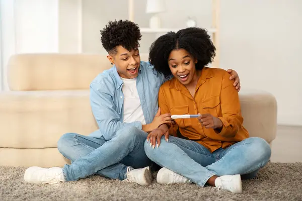 Overjoyed Young African American Couple Sits Floor Positive Pregnancy Test — Stock Photo, Image