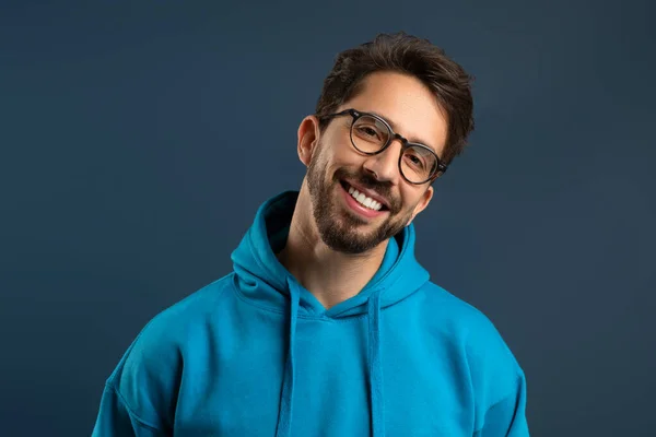 Smiling Young Man Stubble Wearing Glasses Bright Hoodie Standing Blue — Stock Photo, Image