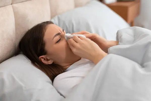 Young Woman Lying Bed Visibly Sick She Blows Her Nose — Stock Photo, Image