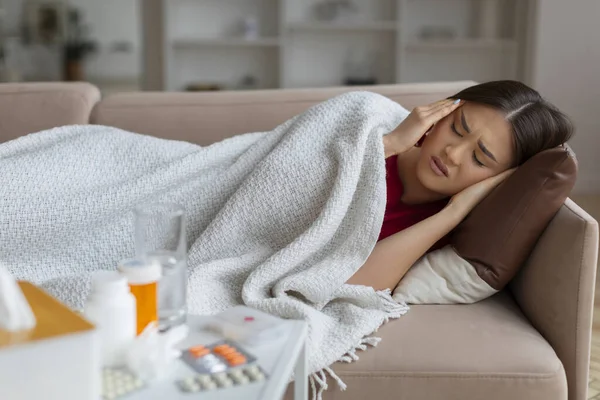 Sick Young Asian Woman Lying Sofa Covered Blanket Medication Visible — Stock Photo, Image