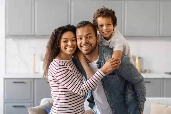 幸せな黒人の親と彼らの息子は家でボンディング 男性の子供が抱擁し カメラで笑う3人の陽気なアフリカ系アメリカ人の家族 一緒に過ごす時間を楽しむ 宇宙をコピーする — ストック写真
