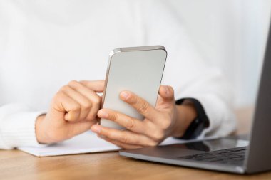 Kadın bağımsız müteahhit ev işlerinde çalışırken aletler kullanıyor. Tanımlanamayan bir bayan bilgisayar dizüstü bilgisayarının önünde oturuyor ve akıllı telefondan kayıyor.