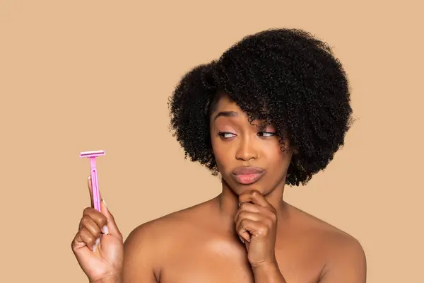 Mujer Negra Joven Pensativa Sosteniendo Afeitadora Rosa Contemplando Idea Afeitarse — Foto de Stock