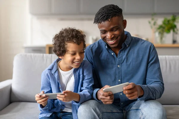 Sonriente Padre Negro Excitado Hijo Pequeño Participan Videojuegos Teléfonos Celulares — Foto de Stock
