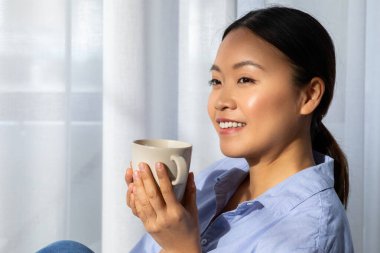 Kahvehane. Rahatlamış, genç Asyalı bir kadının sabahları evde lezzetli kahve içmesinin keyfini çıkarması hafta sonları dinlenmesi, fotokopi çekmesi. Rahatlama, stres atma kavramı