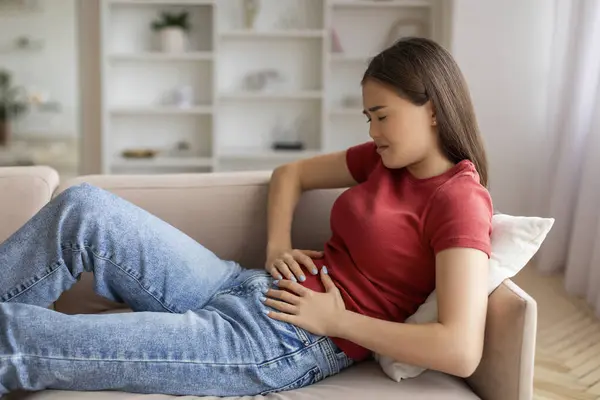 Asian Woman Experiencing Abdominal Pain Home Holding Her Belly While — Stock Photo, Image