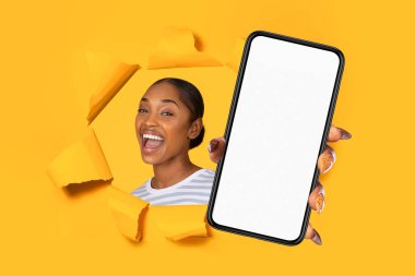Mobil Teklif. Gülümseyen Afro-Amerikan kadın cep telefonuyla sarı kâğıt arkaplanda yırtılmış bir delikten boş ekranla başvuru ilanı için dokunmatik dokunmatik ekran sunuyor. Kolaj
