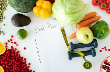 Diyet planı, menü veya program, mezura, dambıl ve diyet gıdaları beyaz masa arkasında taze meyve ve sebze, kilo kaybı ve detoks konsepti, üst görünüm