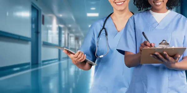 Zwei Lächelnde Gesundheitshelfer Blauem Peeling Eines Mit Stethoskop Und Tablet — Stockfoto