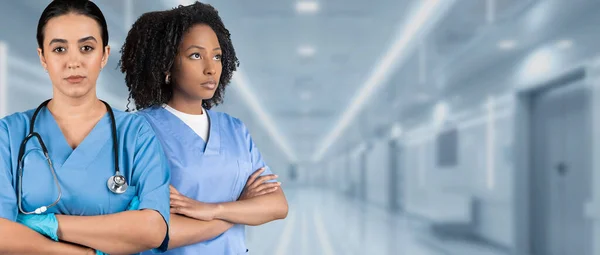 Zwei Seriöse Europäisch Afrikanisch Amerikanische Krankenschwestern Blauem Peeling Mit Verschränkten — Stockfoto