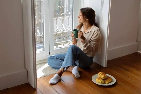 Mujer Joven Sonriente Disfrutando Café Mañana Sentado Suelo Por Ventana — Foto de Stock