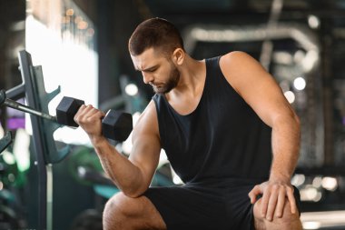 Sakallı Erkek Sporcu Spor Salonunda Kıvırcık Egzersiz Yapıyor, Dambıllarla Kas Genç Adam Eğitimi Modern Spor Kulübü 'nün iç mekânında Hafif Ağırlıklarla Egzersiz Yapıyor, Yakın çekim