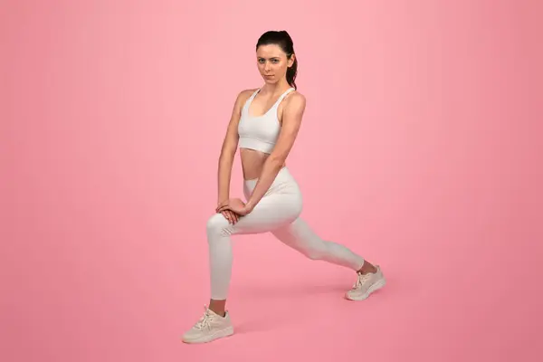 Konzentrierte Europäerin Weißer Sportkleidung Die Eine Dehnübung Ausfallposition Durchführt Und — Stockfoto