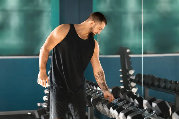 Athletic Young Man Beard Carefully Selects Dumbbells Rack Gym Confident — Stock Photo, Image