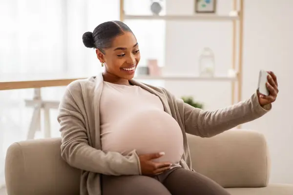 Feliz Joven Afroamericana Mujer Esperando Bebé Sentado Sofá Casa Usando — Foto de Stock