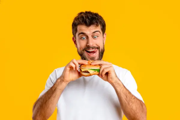 Funny Hungry Bearded Man Looks Burger Temptation Indulges Cheeseburger Embodying — Stock Photo, Image