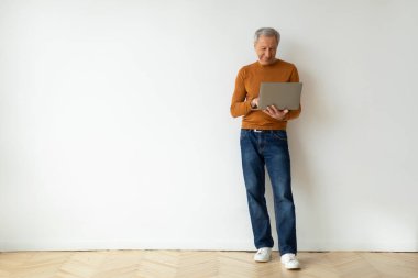 Dedemin elinde dizüstü bilgisayarla boş bir apartmanın arka planında beyaz bir duvar vardı. Çevrimiçi bilgisayar, alışveriş veya bankacılık kullanan yakışıklı bir adam, web sörfü, kopyalama alanı