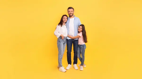 Ebeveynler Kızları Günlük Kıyafetlerini Giyip Sarı Stüdyo Duvarına Karşı Sevgi — Stok fotoğraf