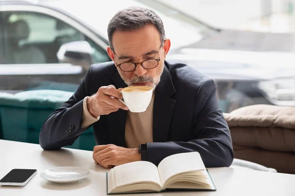 Akıllı Beyaz Tenli Gözlüklü Üst Düzey Işadamı Kitap Okurken Kahve — Stok fotoğraf