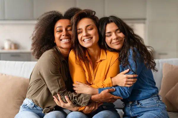 Tre Gioiose Giovani Donne Multietniche Che Abbracciano Sorridono Insieme Sedute — Foto Stock